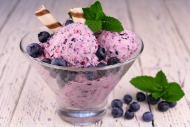 Yaban mersinli dondurma ve beyaz ahşap arka planda nane şekeri..