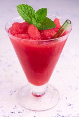 Karpuz ferahlatıcı içecek, beyaz arka planda uzun bir bardakta nane şekeri..