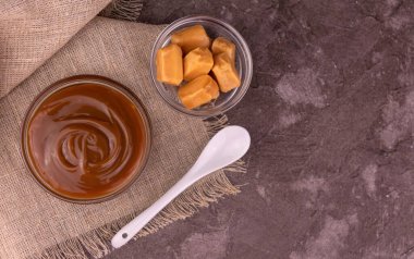 Cam kasede karamel ve gri arka planda karamel. Düz lei. Boşluğu kopyala.