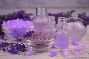 Kâsede lavanta banyosu tuzu, lavanta çiçekleri, aroma yağı, fincanda yüz serumu doğal bitkisel ilaçlar, aromaterapi konsepti..