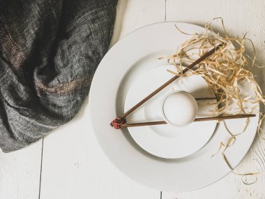Haşlanmış yumurta, beyaz bir tabakta, tahta çubuklarla.