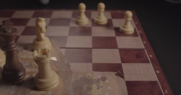 Xadrez e dinheiro em pouca luz. xadrez em um tabuleiro de xadrez com euros — Vídeo de Stock