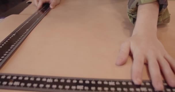 Masters hand met een liniaal tijdens het werken met leer. — Stockvideo