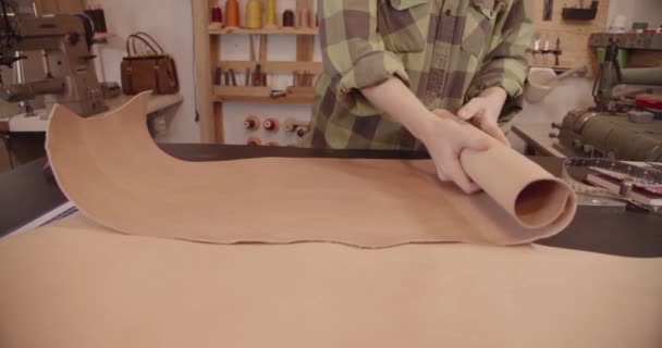 L'artigiano piega un grande foglio di pelle sul tavolo. rallentatore — Video Stock