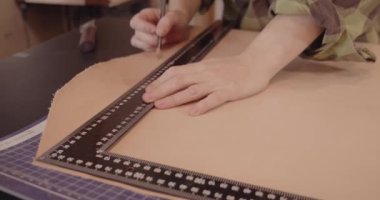 Deri üzerinde çalışırken cetvelle usta eli..