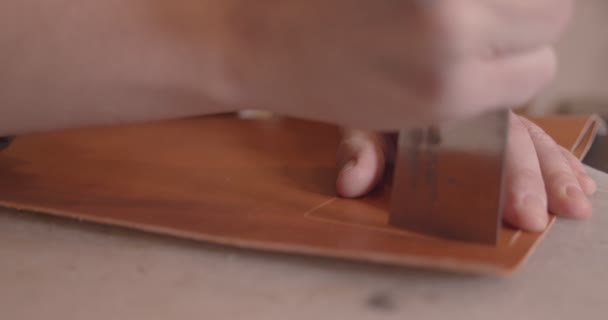Il conciatore taglia la pelle con un coltello, da vicino, al rallentatore — Video Stock