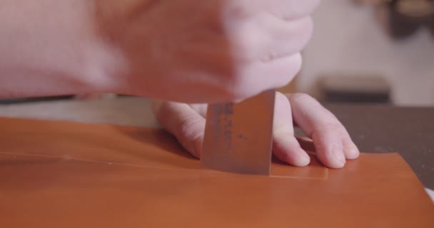 O curtidor corta a pele com uma faca, close-up, câmera lenta — Vídeo de Stock