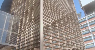 Yüksek ofis binası. Kamera bir ofis gökdeleninin duvarında yavaşça hareket ediyor.