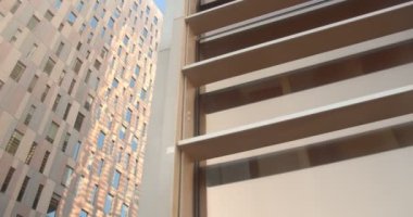 Güneşli havada yüksek bir ofis binasının panoramik videosu.