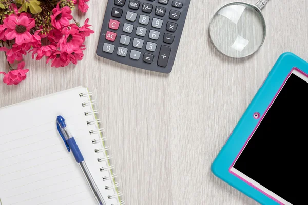 Defter, kalem, Büyüteç'i, hesap makinesi ve tablet pc, ahşap masa arka plan üzerinde. İş kavramı.