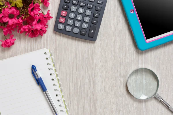 Defter, kalem, Büyüteç'i, hesap makinesi ve tablet pc, ahşap masa arka plan üzerinde. İş kavramı