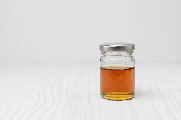Miel sucré en pot isolé sur bois blanc — Photo