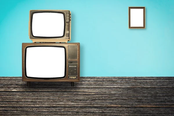 Old Televisions on wooden floor and photo frame on wall