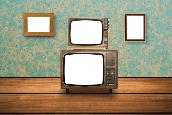 Old Television on wooden floor and photo frames on wall — Stock Photo, Image