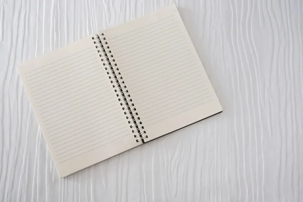 Beyaz ahşap zemin üzerine açık defter