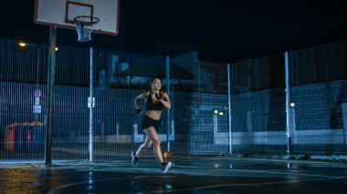 Güzel Energetic Fitness Girl, Açık hava basketbol sahasında koşuyor. Bir Mahalle Mahallesi 'nde Yağmurdan Sonra Gece Çalışıyor.
