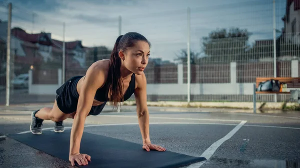 Menina Aptidão Energética Bonita Fazendo Exercícios Push Up. Ela está fazendo um treino em uma quadra de basquete ao ar livre cercada. Dia após a chuva em uma área residencial de vizinhança. — Fotografia de Stock