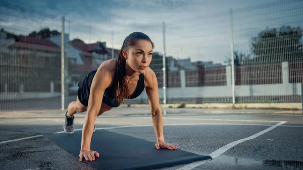 Menina Aptidão Energética Bonita Fazendo Exercícios Push Up. Ela está fazendo um treino em uma quadra de basquete ao ar livre cercada. Dia após a chuva em uma área residencial de vizinhança. — Fotografia de Stock