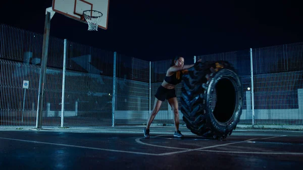 아름다운 건강 한 소녀가 야외 농구 코트에서 운동을 하고 있습니다 . 가까운 이웃 지역에 있는 안개낀 밤에 비가 내린 후에 거대 한 급류를 타고 가는 사람들. — 스톡 사진