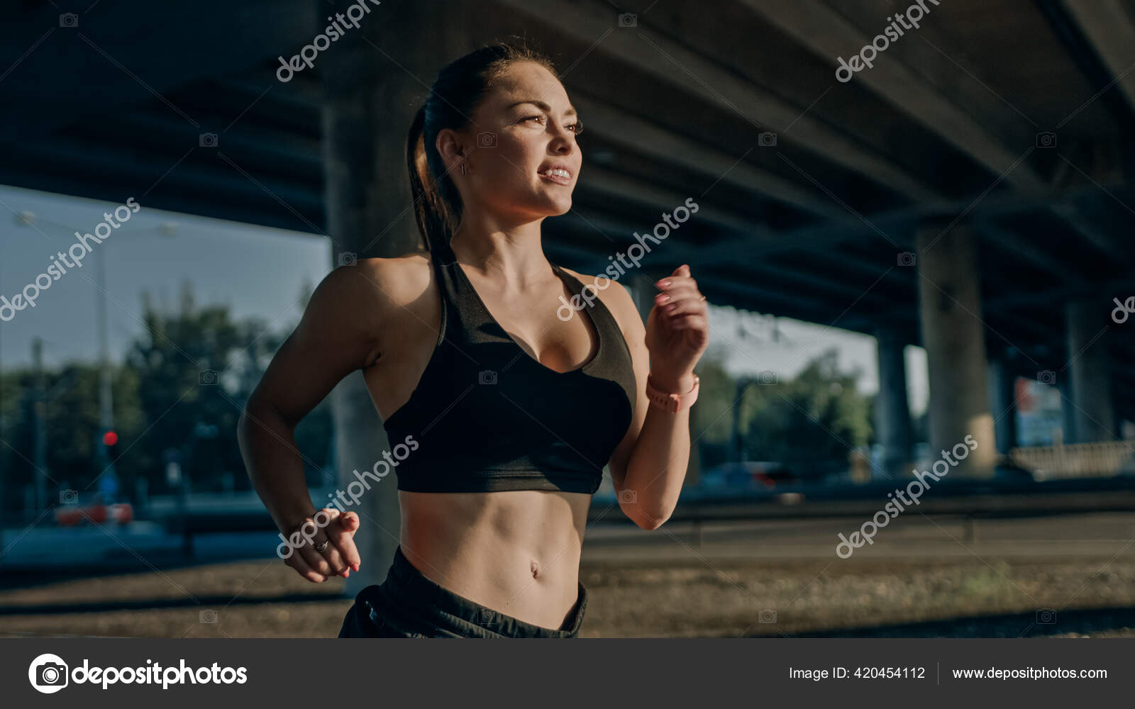 Strong and Fit Beautiful Busty Girl in an Athletic Top is Posing After a  Workout at Home in Her Spacious and Sunny Living Room with Minimalistic  Interior. Stock Photo