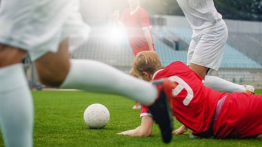 Profesyonel Futbolcu Topun Yakınından Düşer ve Rakipleri. İki Profesyonel Futbol Takımı Oynuyor. Düşük Açı Vuruşu.