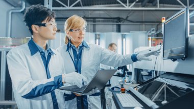 High Tech Factory Worker Reels in Pick and Place Machine 'de, Mühendisler Yazdırma Elektronik Makinelerini Yazdırma Devresi Assembly Line için kullanıyorlar. SMT ile PCB Üretimi