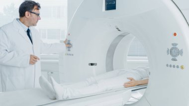 Tıbbi Laboratuvar Radyologları MRI, CT ya da PET taramasında kadın hasta işlemleri yapılıyor. Yüksek Teknolojik Modern Tıbbi Ekipman. Hasta ile Dostane Doktor Sohbetleri.