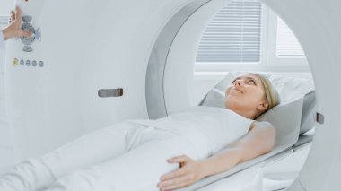 Tıbbi Laboratuvar Radyologları MRI, CT ya da PET taramasında kadın hasta işlemleri yapılıyor. Yüksek Teknolojik Modern Tıbbi Ekipman. Hasta ile Dostane Doktor Sohbetleri.