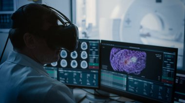 Gelecekçi kavram: Tıbbi Kontrol Odasında Sanal Gerçeklik Kulaklığı takan Doktor, MRI ya da CT tarama prosedüründen geçen Hasta İzleyicileri Gözlemliyor. Bilgisayar Kanserli 3B Beyin Modelini Göster.