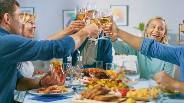 Grote Familie en Vrienden viering thuis, Diverse Groep van mensen verzameld aan de tafel, Clink glazen in een toast. Mensen die eten, drinken en plezier hebben. Feest overdag in de woonkamer. — Stockfoto