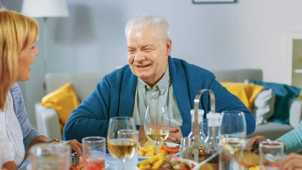 Große Familien- und Freundesfeier zu Hause, vielfältige Gruppe junger Erwachsener und alter Menschen am Tisch haben Spaß beim Gespräch. — Stockfoto