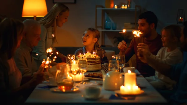 Verjaardagsviering van Schattig Meisje aan de Diner Tafel, Moeder Brengt Taart en Meisje Voorbereiding om Kaarsen uit te blazen. Aan tafel verzamelden gelukkige familieleden en vrienden zich om te vieren. — Stockfoto