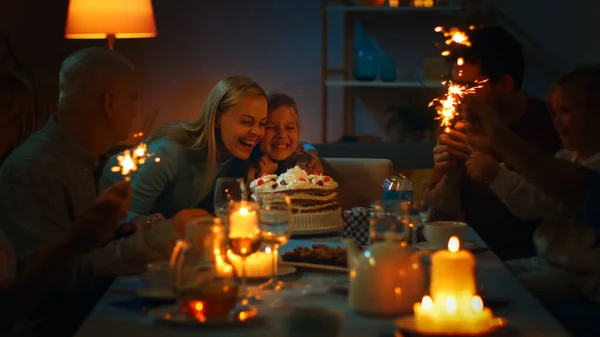 Verjaardagsviering van Schattig Meisje aan de Diner Tafel, Moeder knuffelt haar dochter na het uitblazen van kaarsen. Aan tafel kwamen gelukkige familieleden en vrienden samen om feest te vieren. — Stockfoto