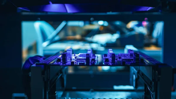 Automated Robotic Industrial Equipment test elektronische printplaat met Purpule Neon Light en lasertechnologie na montage. — Stockfoto