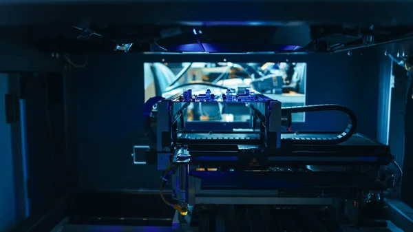 Automated Robotic Industrial Equipment test elektronische printplaat met Blue Neon Light en lasertechnologie na montage. — Stockfoto