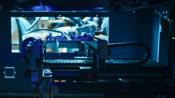 Automated Robotic Industrial Equipment is Testing Electronic Printed Circuit Board with Blue Neon Light and Laser Technology After Assembly. — Stock fotografie