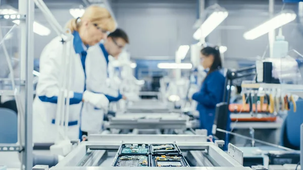Shot van een Electronics Factory arbeiders monteren Circuit Boards met de hand, terwijl het beweegt op de assemblagelijn. Faciliteit voor hightechfabrieken. — Stockfoto