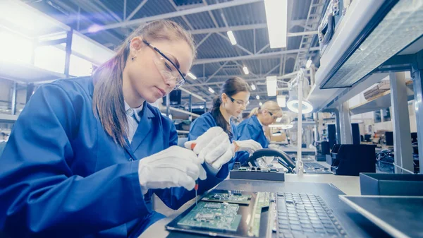 Female Electronics Factory Worker in Blue Work Cloty and Protective Glasses - це материнська плата Assembling Laptops з скринінгом. Висока технічна фабрика з численними працівниками. — стокове фото