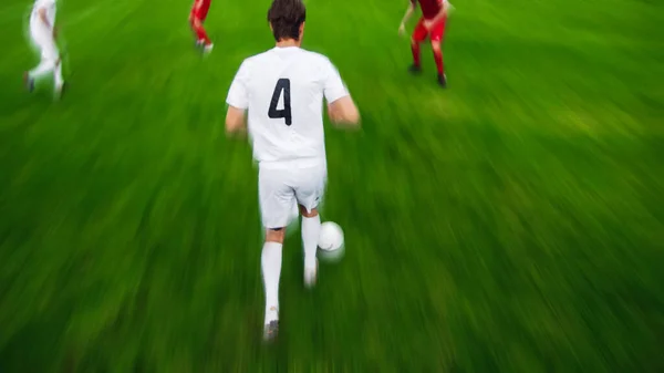 Blurred Motion Upper Follow Shot of Professional Soccer Player Leads with a Ball. Dua tim sepak bola profesional bermain di stadion.. — Stok Foto
