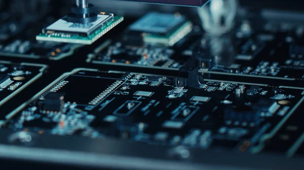 Close-up Macro Shot of Electronic Factory Machine at Work: Nyomtatott áramköri lap A PCB-t automatizált robotkarral szerelik össze, felületre szerelt technológiával SMT Mikrochipek csatlakoztatása az alaplaphoz. — Stock Fotó