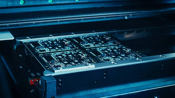 Machine d'usine au travail : Carte de circuit imprimé en cours d'assemblage avec bras robotique automatisé, technologie montée en surface reliant les micropuces à la carte mère. Macro Décryptages. — Photo