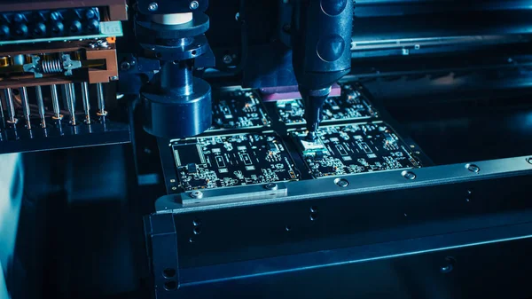 Factory Machinery at Work: Printed Circuit Board Being Assembled with Automated Robotic Arm, Surface Mounted Technology Connecting Microchips to the Motherboard. Macro Close-up.