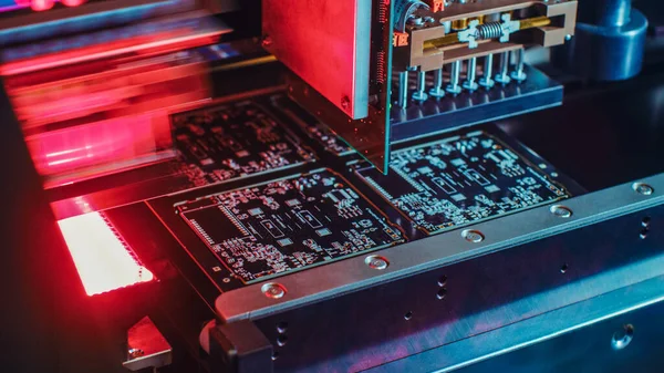 Machines d'usine au travail : Carte de circuit imprimé en cours d'assemblage avec bras robotique automatisé, technologie montée en surface reliant les micropuces à la carte mère. Macro Décryptages. — Photo