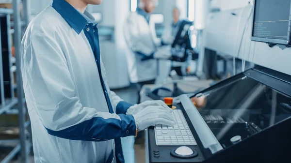 On High Tech Factory Asian Engineer uses Computer for Programing Pick and Place Electronic Machinery for Printed Circuit Board Assembly Line. Výroba plošných spojů se strojním zařízením SM. — Stock fotografie