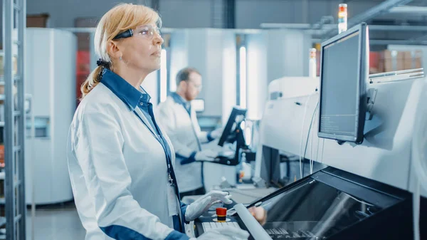 Su High Tech fabbrica ingegnere femminile utilizza il computer per la programmazione Pick and Place Macchinari elettronici per la linea di assemblaggio superficiale del circuito stampato. Produzione di PCB con macchinari SMT. — Foto Stock