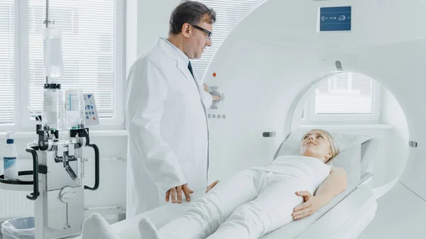 I medicinska laboratorium röntgenläkare kontrollerar MRT eller CT eller PET Scan med kvinnliga patienten genomgår procedur. Högteknologisk modern medicinsk utrustning. Vänliga doktorchattar med patient. — Stockfoto