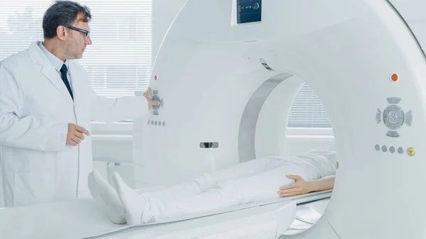 En el laboratorio médico el radiólogo controla la resonancia magnética o la tomografía computarizada o la exploración de la PET con el paciente femenino que se somete a procedimiento. Equipos médicos modernos de alta tecnología. Amistoso Doctor Chats con Paciente. — Foto de Stock