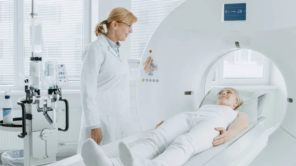 En el laboratorio médico el radiólogo controla la resonancia magnética o la tomografía computarizada o la exploración de la PET con el paciente femenino que se somete a procedimiento. Equipos médicos modernos de alta tecnología. Amistoso Doctor Chats con Paciente. —  Fotos de Stock