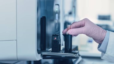 Yakın plan kadın araştırmacı bilim adamları, Kan örneğiyle Test Tüpü 'nü tutuyor ve Tıbbi Analiz Ekipmanlarına yerleştiriyor. Modern İlaç Laboratuvarında Bilim Adamı Çalışıyor