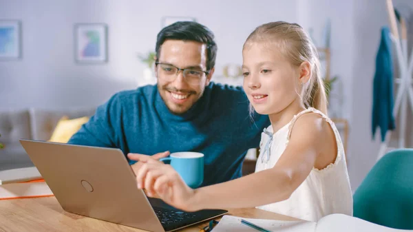 Un enseignant talentueux donne une leçon privée avec une jeune fille brillante à la maison. Enseignant de langues étrangères Tuteurs Smart Little Girl. Ils utilisent un ordinateur portable et écrire dans le manuel. — Photo